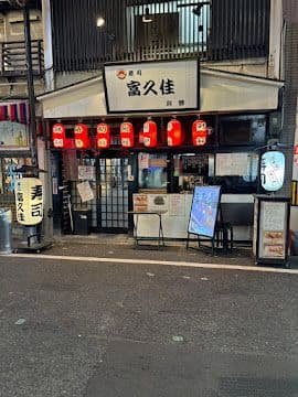 通りから見た富久佳 別館の店頭。赤提灯と「寿司 富久佳」の白い行灯が灯る