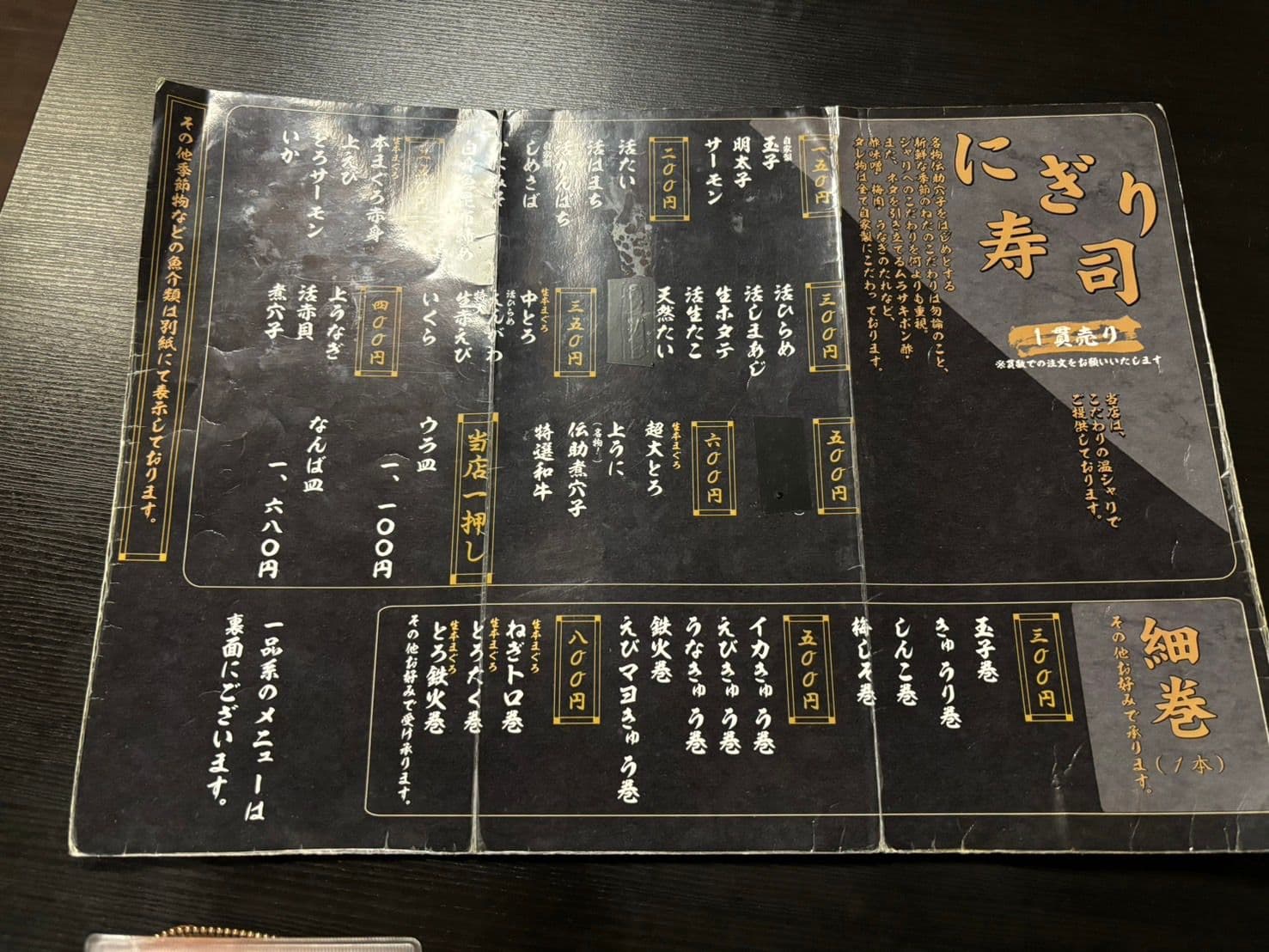富久佳 別館のお品書き。にぎり寿司の一貫売りと細巻の価格が並ぶ面