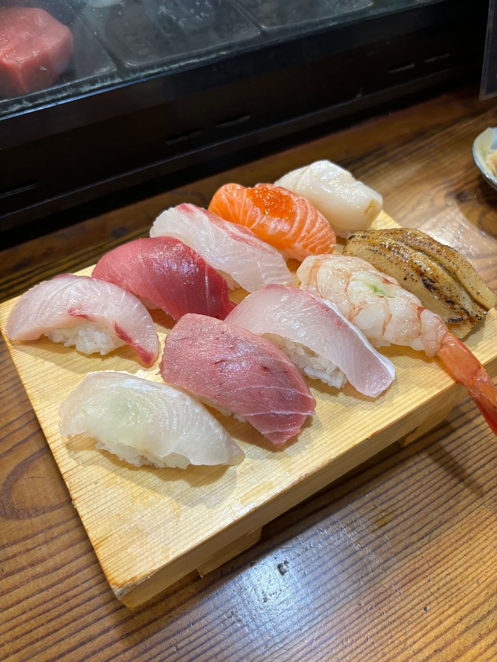 つけ台に盛られたにぎり寿司の盛り合わせ。炙り穴子、海老、サーモン、帆立、鮪、白身が並ぶ