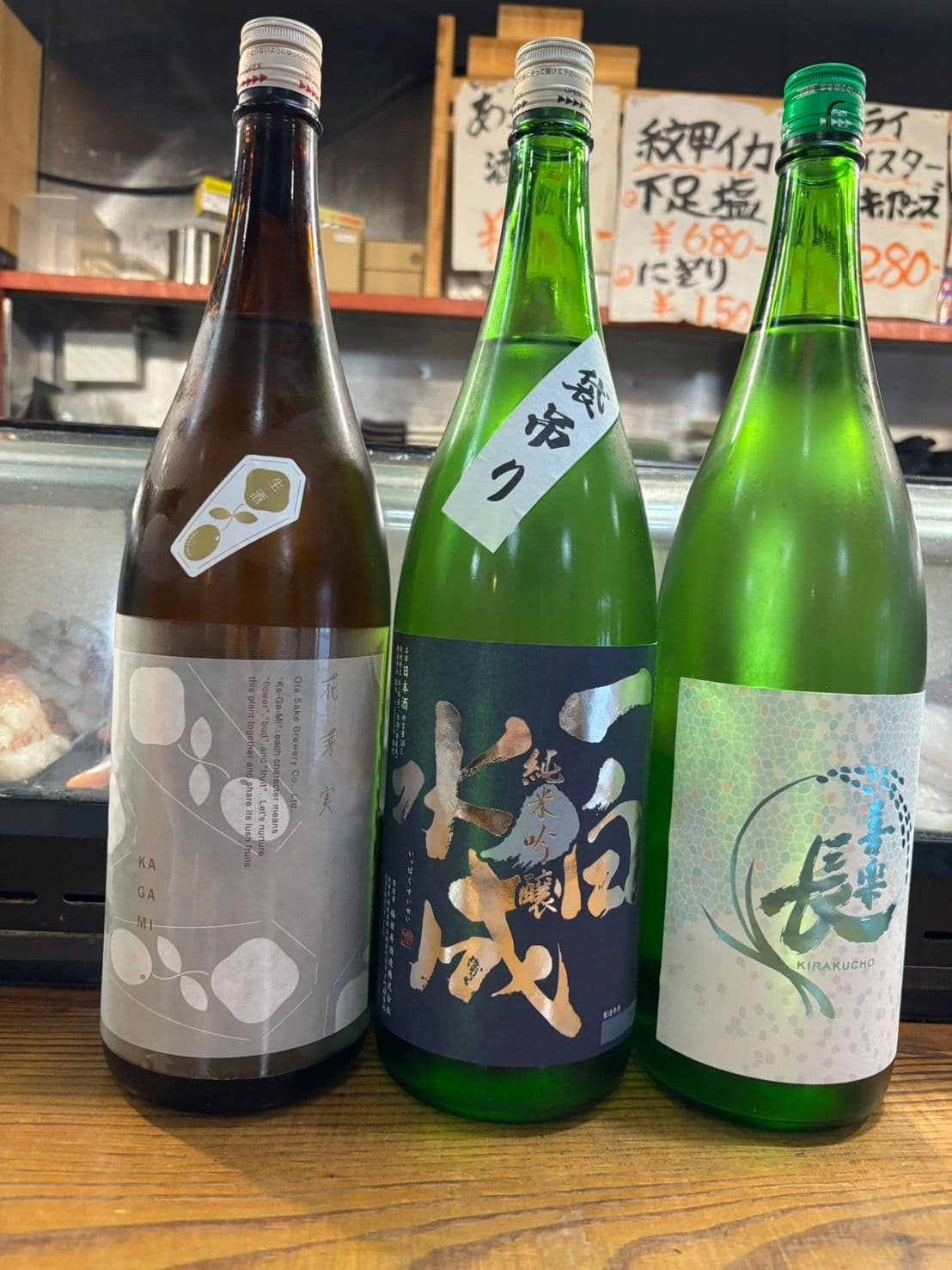 店内に並ぶ純米吟醸を含む日本酒の一升瓶三本