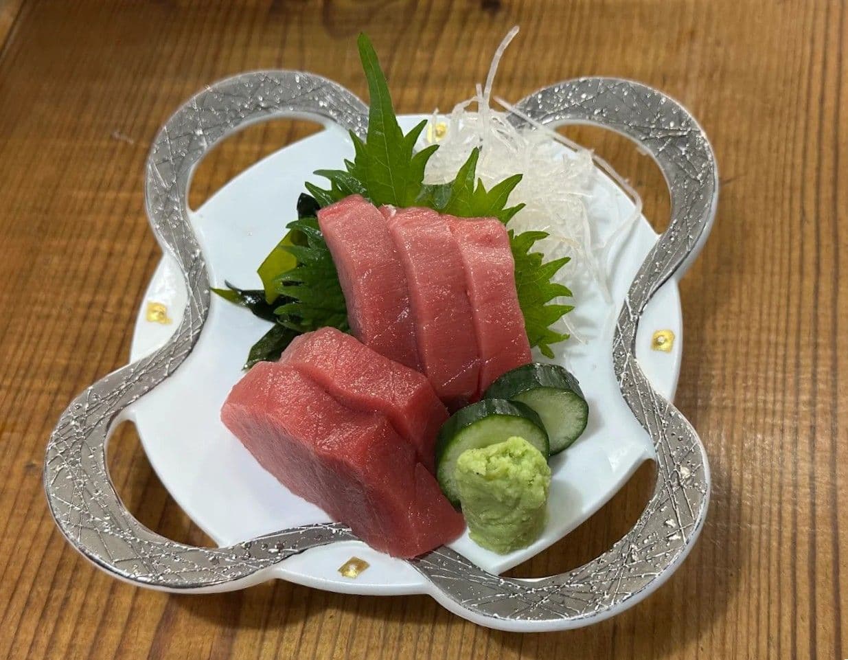 銀彩の器に盛った本鮪の刺身。大葉、大根のつま、わさび添え